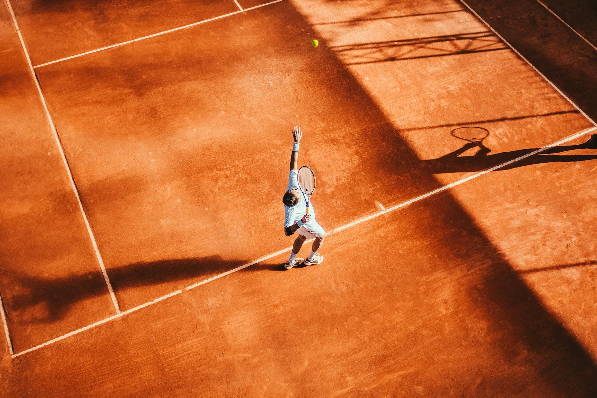 man-playing-tennis-clay-court